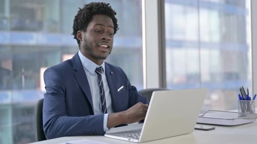 Young Adult in Suit Video Conferencing at Office