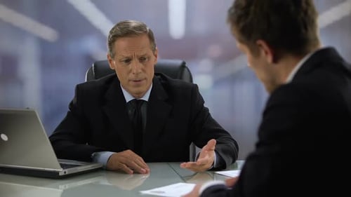 Un candidat remet son curriculum vitae au chef de l'entreprise lors d'un entretien d'embauche