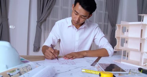 Architect Drawing Architectural Plans at Desk