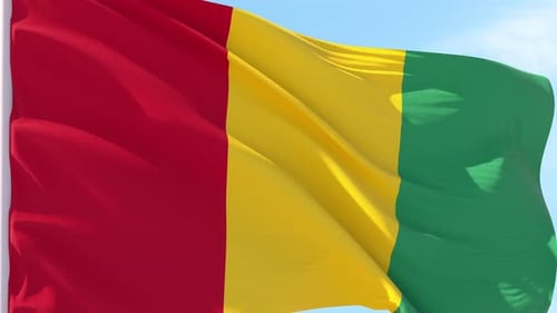Realistic Waving Flag of Guinea against Blue Sky