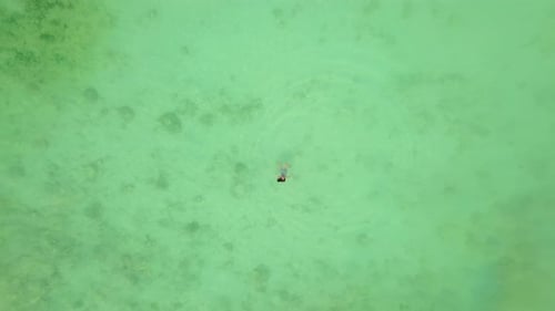 Aerial view of happy Asian woman swimming at turquoise sea in Phuket.Thailand