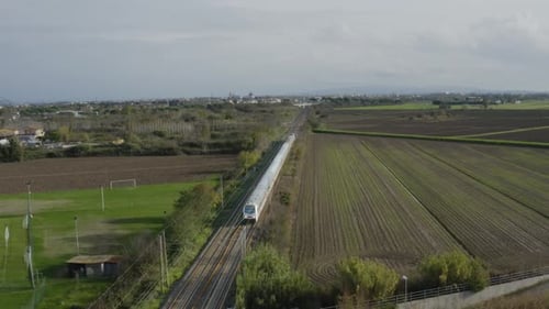 Scenic Aerial View of Fast Train Through Fields
