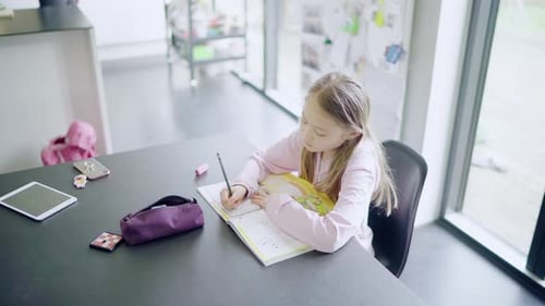 Girl Doing Homework at Table Indoors