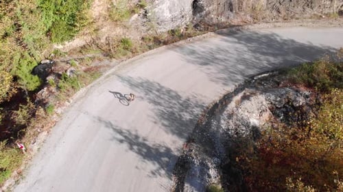 Professional cyclist descending from mountain pass on road bicycle.
