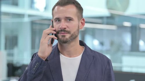 Young Adult Talking on Cell Phone in Office