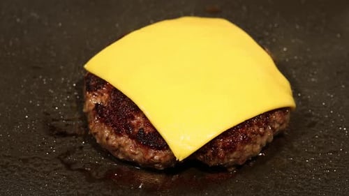 Cheeseburger Patty Cooking on a Grill Close Up