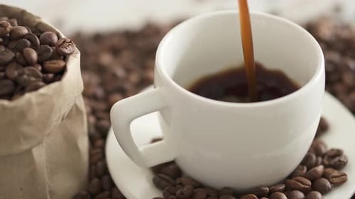 Pouring Hot Coffee into White Cup