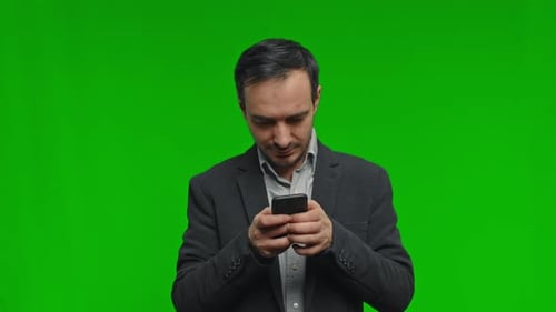 Thoughtful Man in Suit Using Phone Over Isolated Green Background