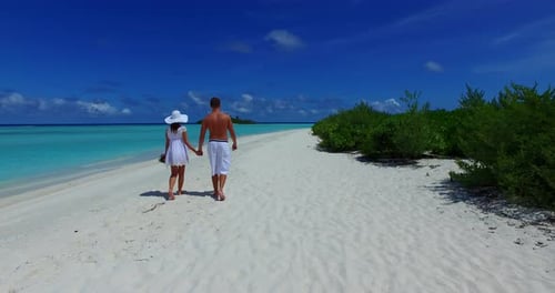 Young lady and man on honeymoon vacation have fun on beach on clean white sand background