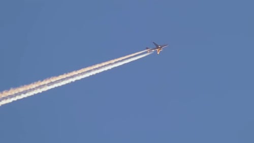 Airplane Flying Leaving Contrails in Blue Sky