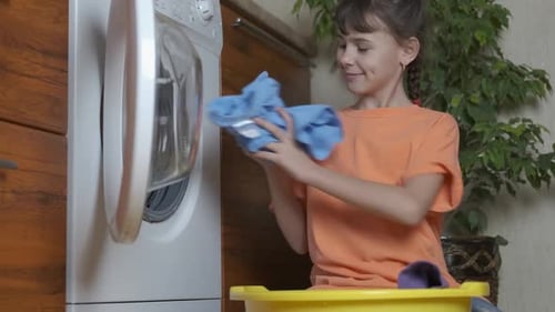 Ein Kind hilft der Mutter beim Wäschewaschen.