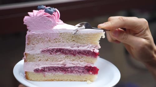 Healthy Delicious Vegan Desserts. Close Up of Fork Breaking a Piece of Layered Vegan Cake with Cream