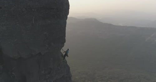 Cinematic drone shot of rock climbers climbing a multi pitch sports route on a basalt rock pinnacle
