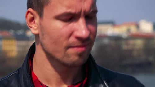 A Young Handsome Man Takes Photos with a Camera - Face Closeup - a Town and the Sky