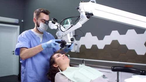 Dentist Using Microscope on Patient in Dental Office