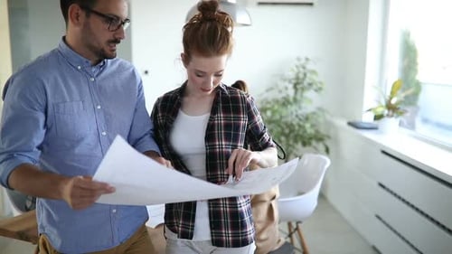 Young Adults Reviewing Document in Office