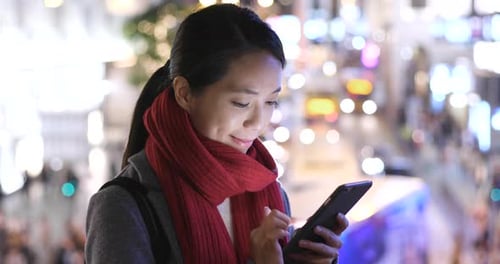 Woman use of mobile phone in city over traffic road background