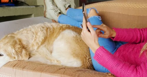 Woman Relaxes with Golden Retriever on Couch