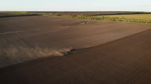 Aerial View Modern Red Tractor on the Agricultural Field on Sunset Time, Tractor Plowing Land and