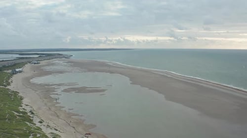 Establishing Aerial Wide View of North Sea Beach with Huge Water Puddles and Kitesurfers Training
