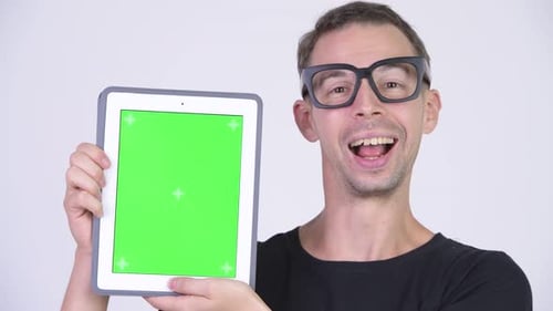 Studio Shot of Happy Nerd Man Showing Digital Tablet