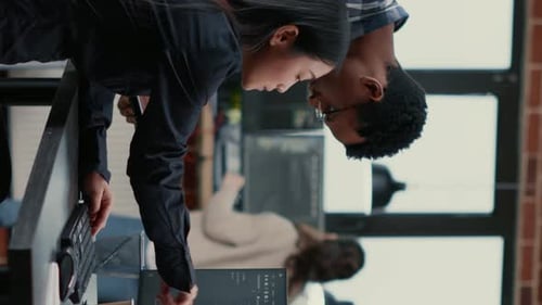 Vídeo vertical Equipe mista de desenvolvedores de software analisando o código-fonte apontando para telas comparando
