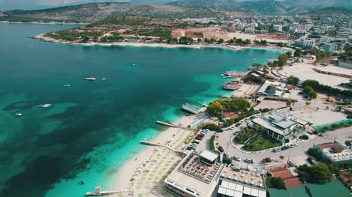 Aerial Azure Beach with Empty Sun Loungers and Boats Balkan Sea Coast Albania