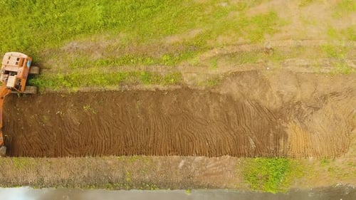 Excavator Digging a Trench in the Field