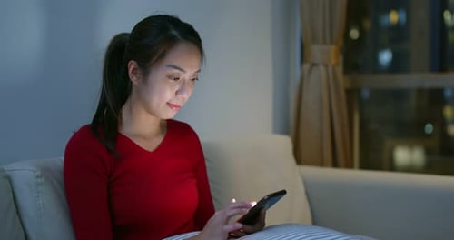 Young Woman Using Smartphone at Night in Apartment