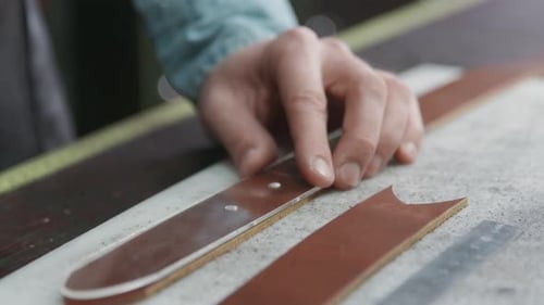 Working Process of the Leather Belt in the Leather Workshop. Man Holding Crafting Tool and Working