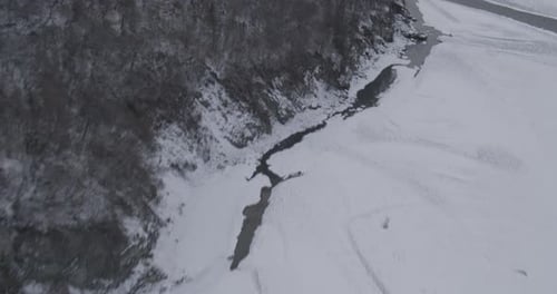 Aerial View of Snowy River in Winter Landscape