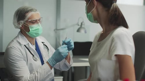 Doctor Prepares Syringe for Patient Vaccination in Office