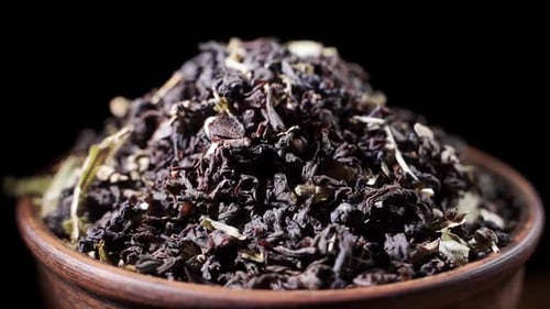 Loose Leaf Tea Rotating in Wooden Bowl Close Up