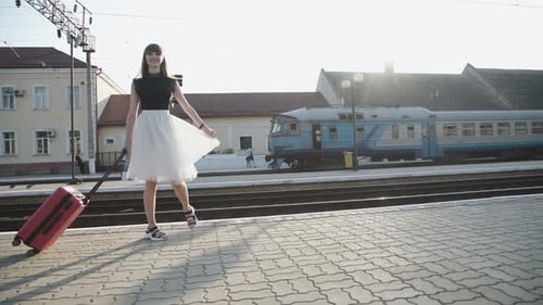 Young Woman Walking With Suitcase at Train Station