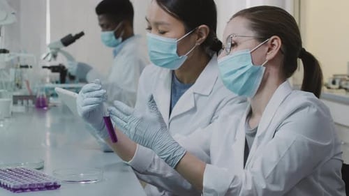 Scientists Working in Lab Examining Test Tube