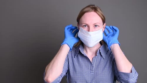 Woman Puts on a Protective Surgical Mask