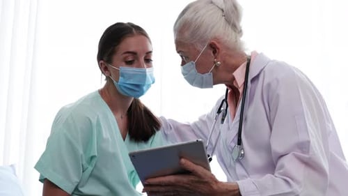 Doctor Reviewing Tablet with Concerned Young Adult Patient