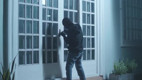 Burglar Breaking Into a House at Night