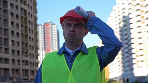Construction Worker with Plans on Building Site