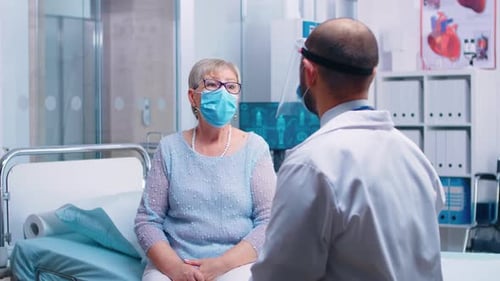 Senior Woman Consults Doctor in Hospital Room