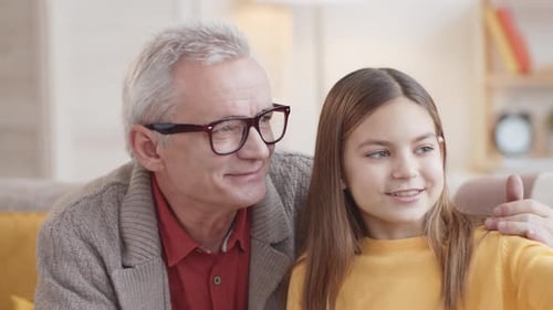 Grandchild and Grandfather Take Selfie Together Indoors