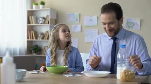 Father and Daughter Eating Breakfast Together at Home