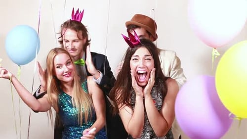 Four crazy friends having a great time in photo booth