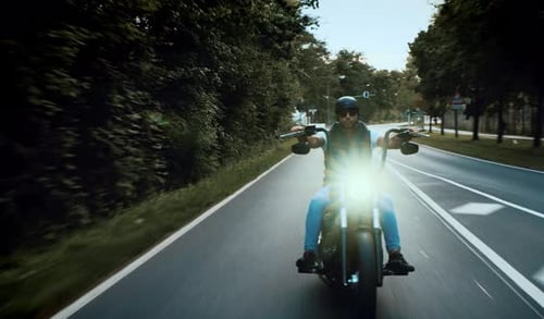 Motorcycle Rider on Road With Trees