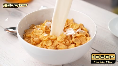 Pouring Milk Over Crunchy Cornflakes in Bowl