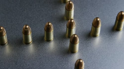 Cinematic rotating shot of bullets on a metallic surface - BULLETS