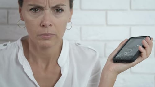 Woman Looks at Mobile Phone with Shattered Screen
