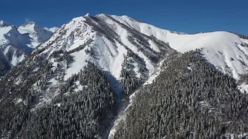 Air flight through mountain clouds over beautiful snow-capped peaks of mountains and glaciers.