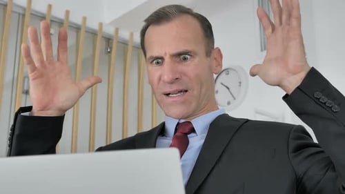 Upset Businessman Reacting to Bad News on Laptop