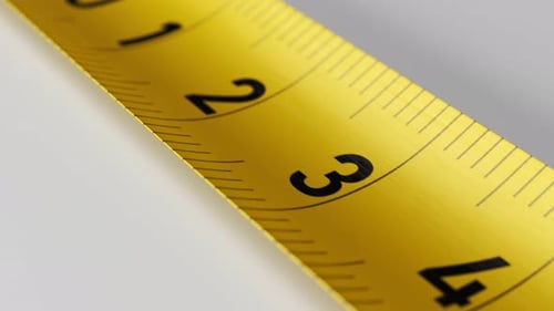 Camera moves along the yellow tape measure in endless loop. Close-up shot.